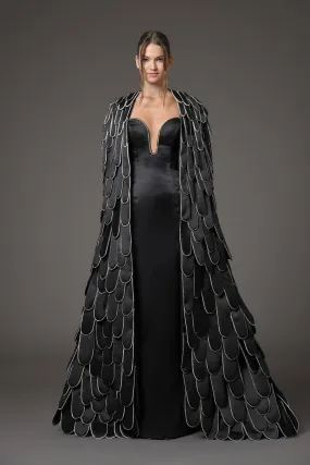 Black silk scuba dress featuring a cape with an overflow of layered 3D hand-crafted plumes in scuba and crystals