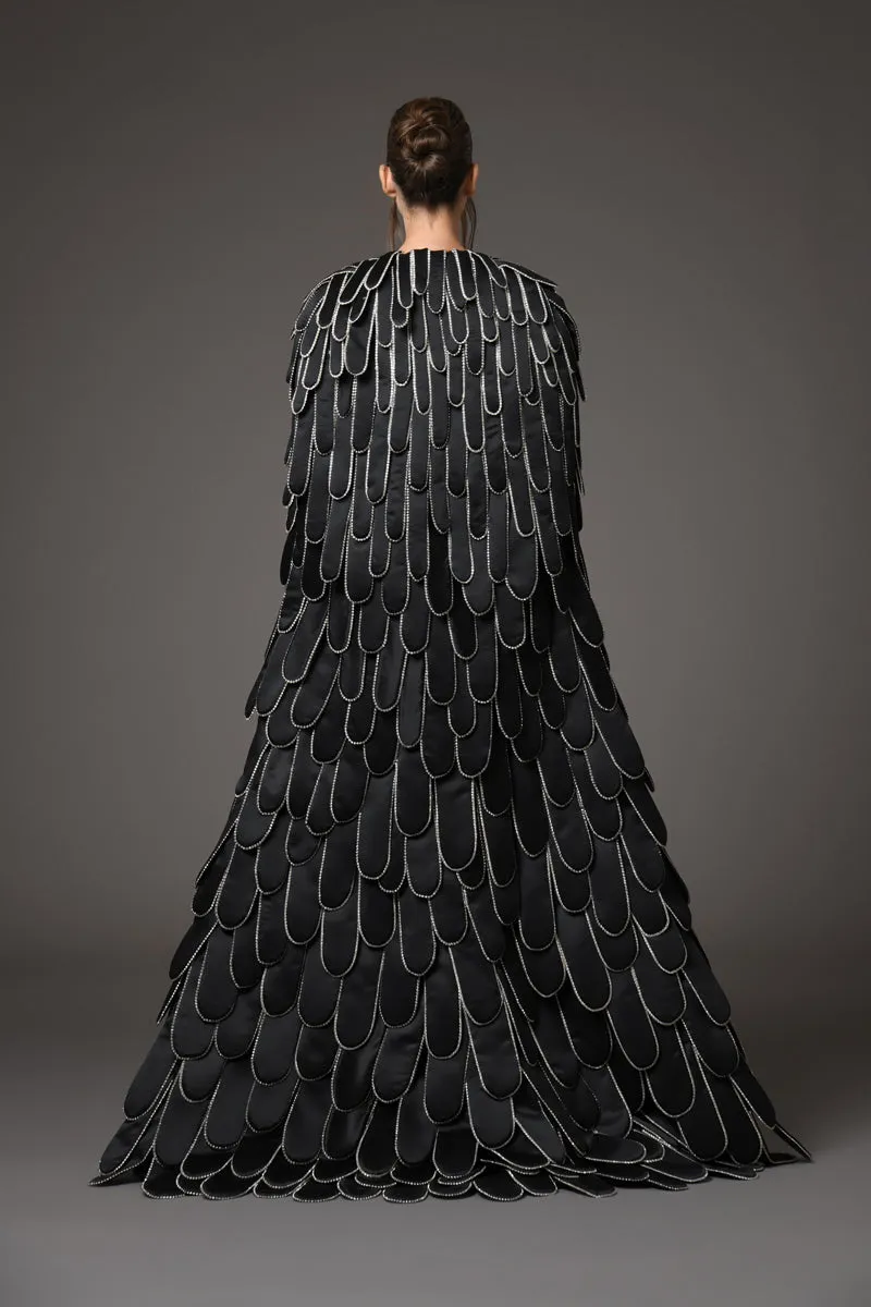 Black silk scuba dress featuring a cape with an overflow of layered 3D hand-crafted plumes in scuba and crystals