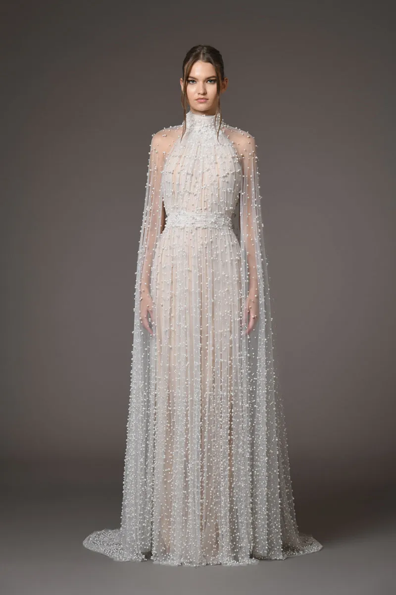 Halter neck bridal gown featuring a cape adorned with cascading pearls