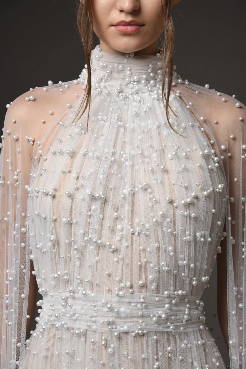Halter neck bridal gown featuring a cape adorned with cascading pearls
