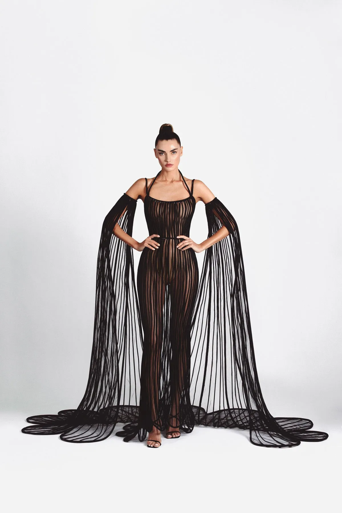 Sheer mermaid signature dress in black latex and tulle worn with cape sleeves handcrafted in 3D tubes